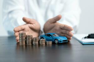 de cerca de un de la persona mano proteger creciente apilado monedas y azul coche. ahorro dinero para coche concepto, comercio coche para efectivo concepto, Finanzas concepto. foto