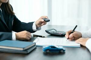 Closeup asian women people car saler or sales manager offers to sell a car and explains and reads the terms of signing a car contract and insurance. photo