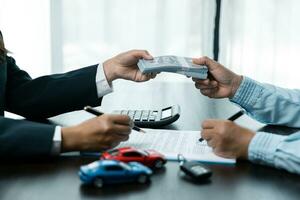 Closeup asian women people car saler or sales manager offers to sell a car and explains and reads the terms of signing a car contract and insurance. photo