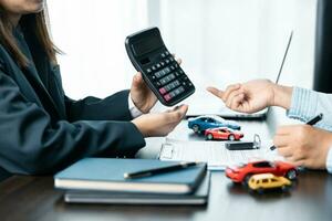 Closeup asian women people car saler or sales manager offers to sell a car and explains and reads the terms of signing a car contract and insurance. photo