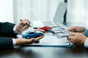 Closeup asian women people car saler or sales manager offers to sell a car and explains and reads the terms of signing a car contract and insurance. photo