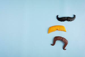 Curly mustaches on colorful background. Fake mustache. Top view photo