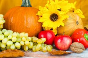 Thanksgiving holiday concept. Seasonal vegetables and fruits on a wooden background. Close-up. Selective focus. photo