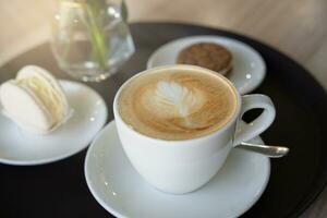 A cup of fresh aromatic cappuccino and dessert on a table in the cafe. Selective focus. photo