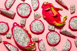 rebanadas de Fresco blanco pitaya o continuar Fruta en rosado fondo, plano laico foto