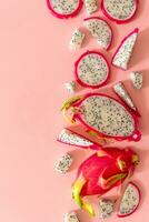 Slices of fresh white pitaya or dragon fruit on pink background, flat lay photo