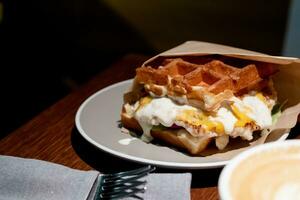 Belgian waffles with eggs and bacon. Breakfast in cafe photo