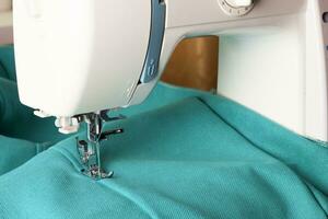 Modern sewing machine and turquoise fabric photo