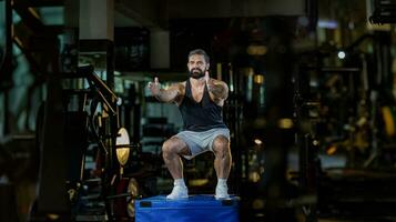 Caucasian man with strong and muscular firm shape is training on leg day by doing advance jump squat for thigh and calf muscle in gym for healthy and strong lower body weight strength photo