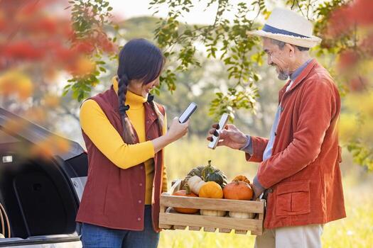 Farmer family buying organics homegrown produce harvest with squash and pumpkin while selling at car trunk in local market using qr code with fall color from maple tree during autumn season usage photo