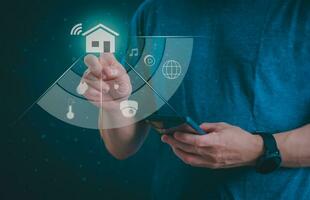 Man using a smartphone, controlling an intelligent home automation system Futuristic interface on a virtual screen Automation technology of things, concept Data connection with technology internet. photo