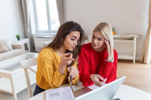female students cooperating together in university campus searching information for learning on internet websites via new modern laptop computer using free wifi connection indoors photo