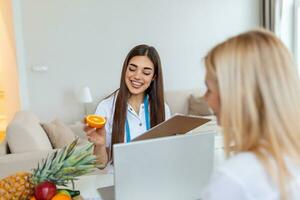 nutricionista profesional que se encuentra con un paciente en la oficina y frutas saludables con cinta métrica, alimentación saludable y concepto de dieta foto