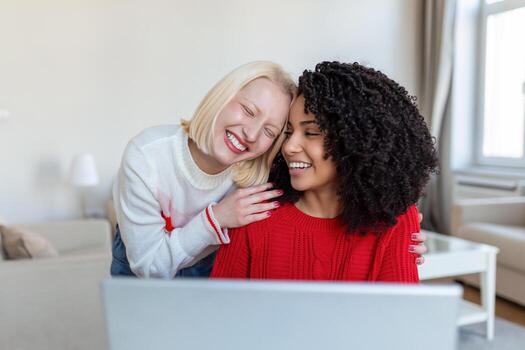 female students cooperating together in university campus searching information for learning on internet websites via new modern laptop computer using free wifi connection indoors photo