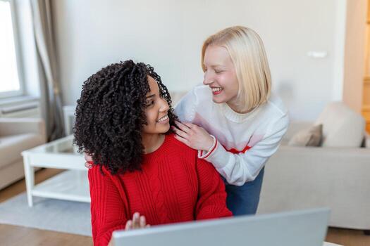female students cooperating together in university campus searching information for learning on internet websites via new modern laptop computer using free wifi connection indoors photo