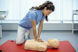 CPR class with instructors talking and demonstrating firt aid, compressions ans reanimation procedure. Cpr dummy photo