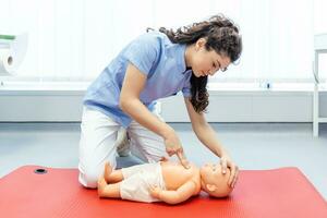 mujer ejecutando cpr en bebé formación muñeca con uno mano compresión. primero ayuda formación - cardiopulmonar resucitación. primero ayuda curso en cpr ficticio. foto