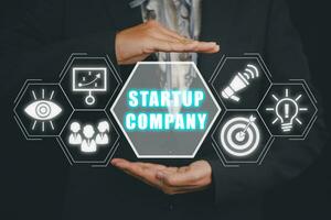 Startup company concept, Businesswoman hand holding start up company icon on virtual screen. photo