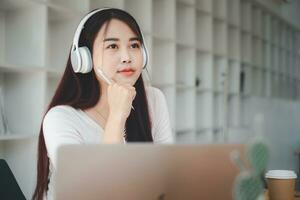 bonito joven mujer escuchando a música con ordenador portátil computadora y relajante mientras sentado en silla a hogar. foto