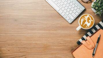 Office wooden desk with keyboard, notebook, pen, mouse and cup of coffee, Top view wth copy space, Flat lay. photo