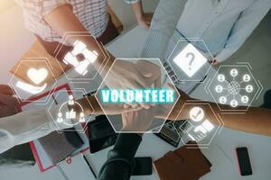 voluntario concepto, grupo de persona unión manos juntos con trabajar como voluntario icono en virtual pantalla. foto