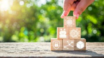 Artificial Intelligence AI, Man hand holding wooden cube block with Artificial Intelligence icon with copy space, Internet of Things IoT concept. photo