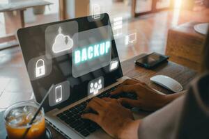 Backup storage data internet technology business concep, Businesswoman using a computer with VR screen backup icon on desk. photo