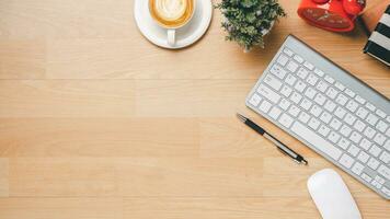 Office wooden desk with keyboard, notebook, pen, mouse and cup of coffee, Top view wth copy space, Flat lay. photo