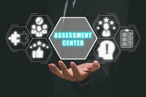 Assessment center concept, Businessman hand holding assessment center icon on virtual screen. photo