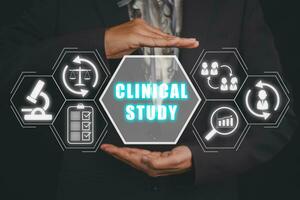 Clinical study concept, Business woman hand holding clinical study icon on virtual screen. photo