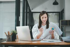 Businesswoman working in Stacks of paper files for searching and checking unfinished document achieves on folders papers at busy work desk office photo