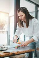 Businesswoman working in Stacks of paper files for searching and checking unfinished document achieves on folders papers at busy work desk office photo