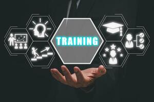 Training concept, Businessman hand holding training icon on virtual screen. photo