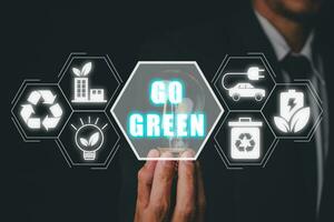 Go green concept, Businessman hand holding light bulb with go green icon on virtual screen. photo