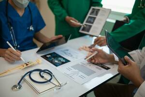 concept of mobilizing ability of medical team in conference room to diagnose and treat disease correctly. medical team joins meeting and discusses  patient illness in order to treat it correctly photo