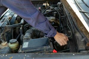 car mechanic is checking condition of engine to make it ready for use and mechanic is still maintaining worn out equipment to return to normal operation. checking engine conditions before traveling photo