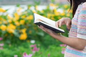 Young woman holding up a Bible to read because she wants to learn the teachings of God from the Bible with faith and faith in God. The concept of learning the teachings of God from the Bible. photo