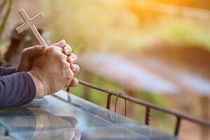 The hand of a young man praying to God for the power of God to fulfill the request of the Christian faith. The young man prayed to God for blessings based on his faith and power of faith in Him. photo