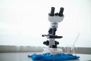 medical gloves and microscope are placed ontable in lab to prepare virologists who want to use lab to examine samples of virus they received from epidemic. Medical equipment for use in laboratorie photo