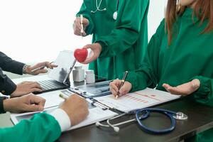 el médico asistió un reunión con un equipo de cardiólogos a discutir cirugía planes para un corazón paciente después el médico equipo descubierto un agujereado corazón válvula y requiere urgente médico atención. foto