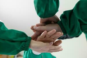 médico unirse manos con cirujano equipo a espectáculo confianza después médico equipo tiene discutido cáncer cirugía planes con cirujano equipo. colaborativo concepto de médico y cirujanos en cirugía. foto