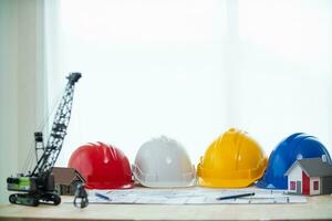 amarillo casco fueron preparado para construcción ingenieros a vestir antes de entrando el construcción zona a evitar peligro de que cae objetos desde laboral. amarillo la seguridad casco es metido en blanco mesa. foto