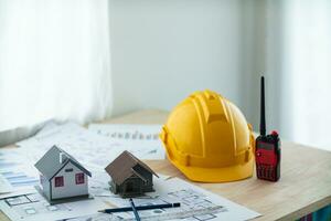 Yellow helmet were prepared for Construction engineers to wear before entering the construction area to prevent  danger of falling objects from working. Yellow safety helmet is placed on white table. photo