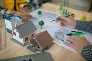 Construction engineers discuss and exchange ideas with architects to improve house plans to meet customer needs. A concept for exchange of design ideas between construction engineers and architects. photo