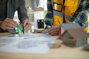 Construction engineers discuss and exchange ideas with architects to improve house plans to meet customer needs. A concept for exchange of design ideas between construction engineers and architects. photo