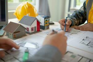 Construction engineers discuss and exchange ideas with architects to improve house plans to meet customer needs. A concept for exchange of design ideas between construction engineers and architects. photo