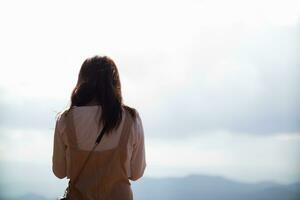 Back scene of woman alone with feeling lonely and depressed on blurred background of beautiful nature scenery . concept of woman who had to be alone in past was depressed when she encountered problems photo