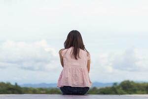 Back scene of woman alone with feeling lonely and depressed on blurred background of beautiful nature scenery . concept of woman who had to be alone in past was depressed when she encountered problems photo