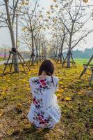 young woman blessed the view of flower garden that looks beautiful in summer alone. Young woman tourists admiring beauty of summer scenery and beautiful flower gardens Copy Space for text photo