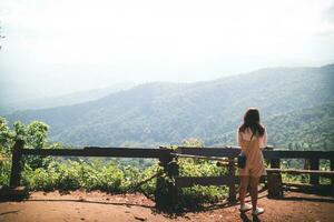 Back scene of woman alone with feeling lonely and depressed on blurred background of beautiful nature scenery . concept of woman who had to be alone in past was depressed when she encountered problems photo